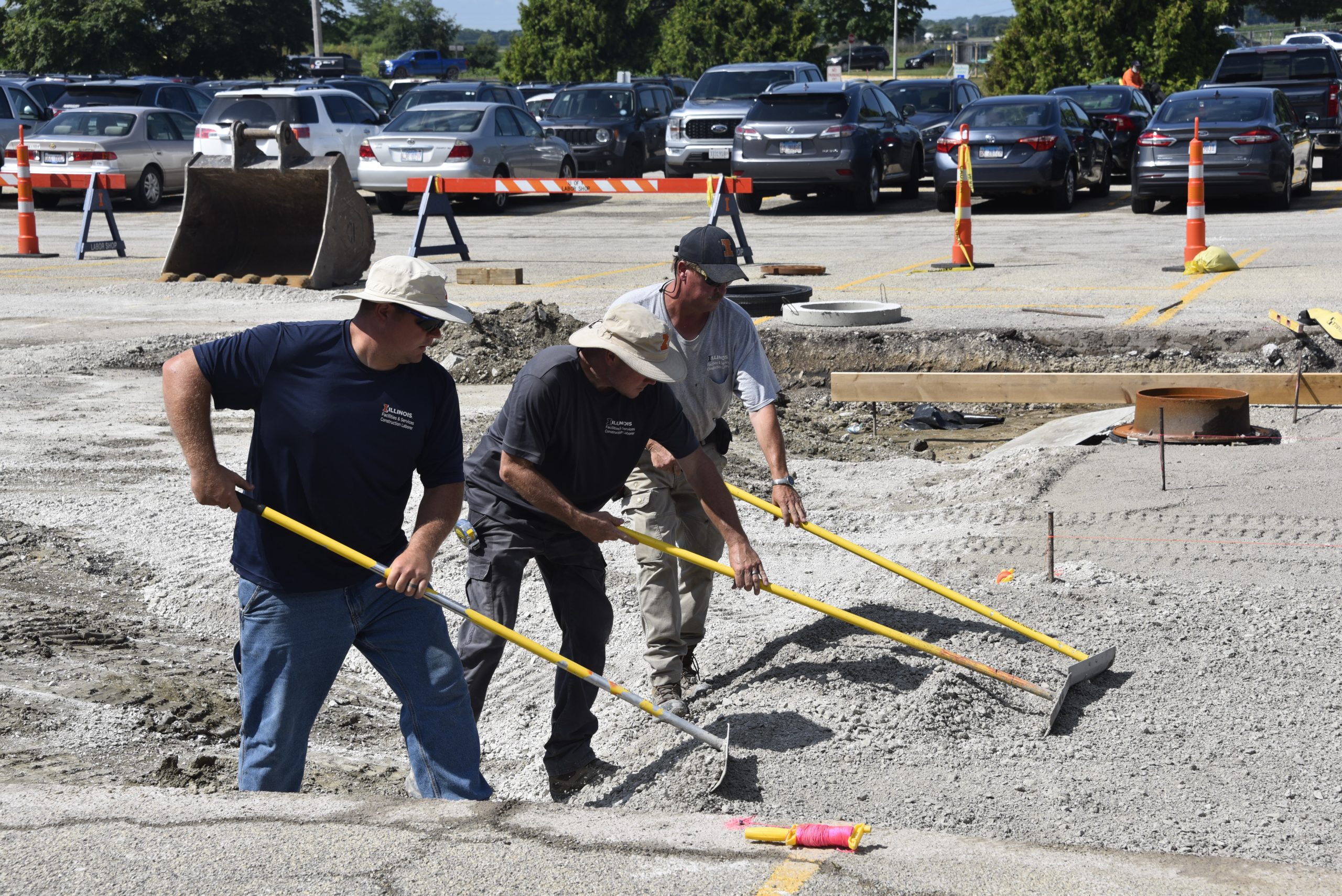 F&S construction laborers raking base layer rock at Lot F27