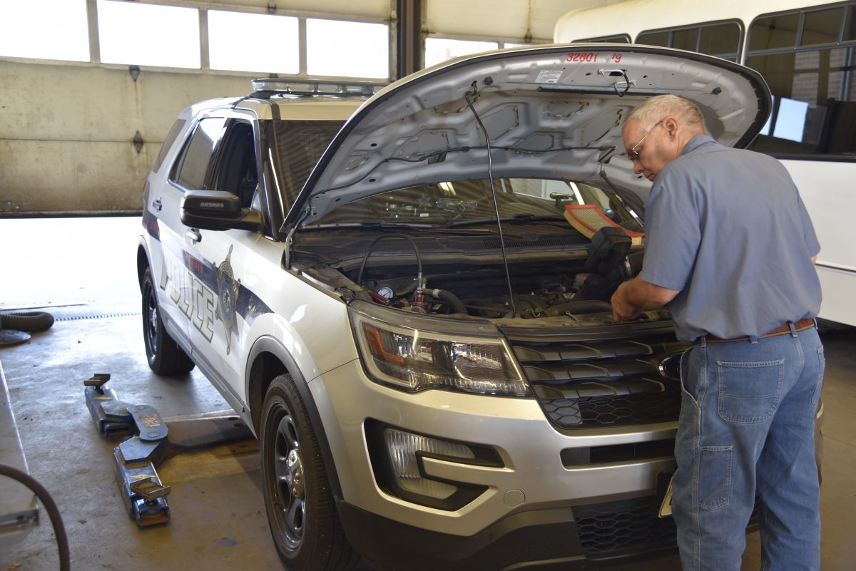 Garage mechanic works on a UIPD dispatch vehicle.