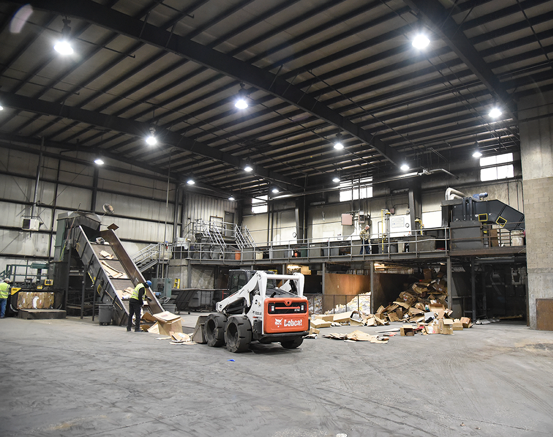 Inside look at the Waste Transfer Station and cardboard recycling efforts with a front loader and conveyor belt