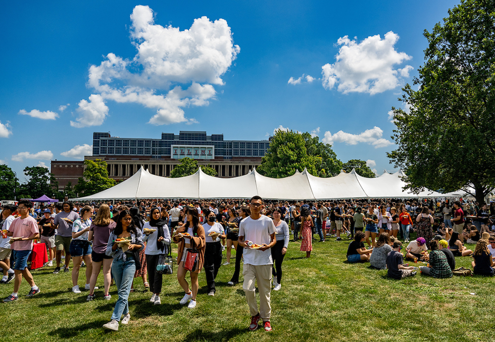 Individuals congregating at a food tent during New Student Convocation