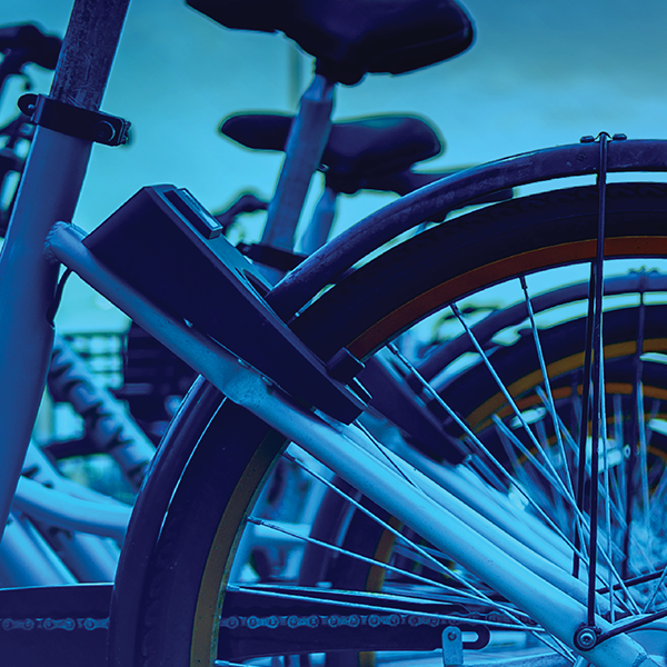 Spokes and seat of multiple bicycles - the image is in different shades of blue