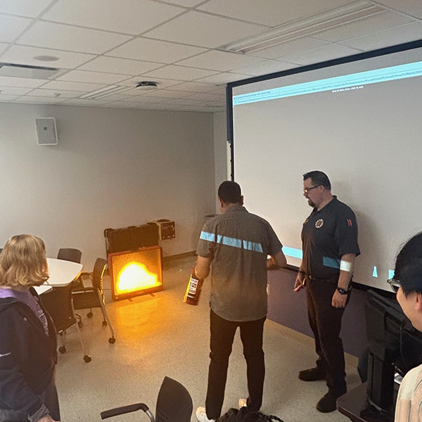 A participant shown putting out a digitally simulated fire with an digital fire extinguisher