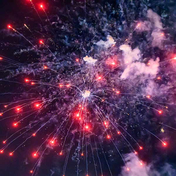 Red, white, blue fireworks exploding in the sky