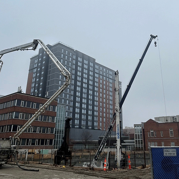 Exterior site view of the Illini Hall Replacement Project construction site that shows concrete pouring activities to support foundation work.