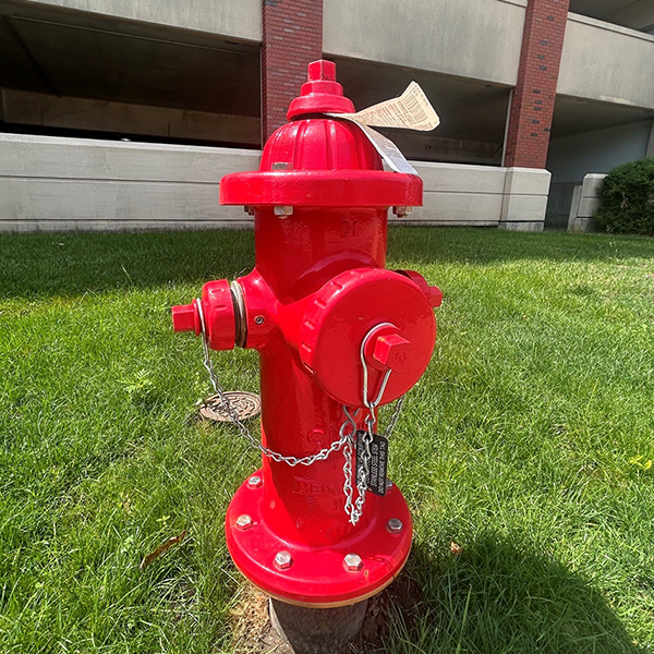 A red fire hydrant in front of one of the parking structures on the Urbana campus