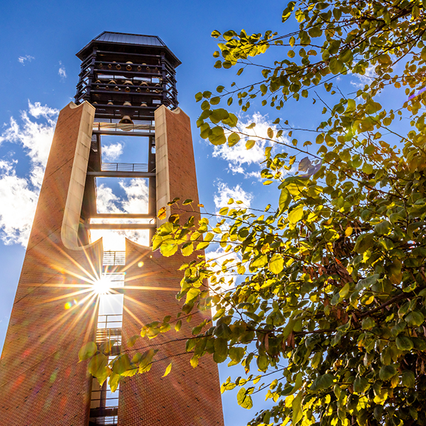 McFarland Memorial Bell Tower on South Quad in fall with a bright sun shining through the chimes location
