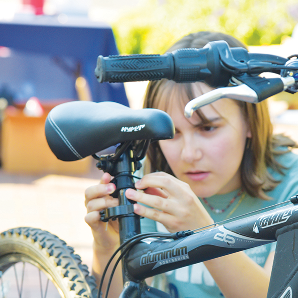 A volunteer installs a rear bike light by attaching the clamp to the seat post.